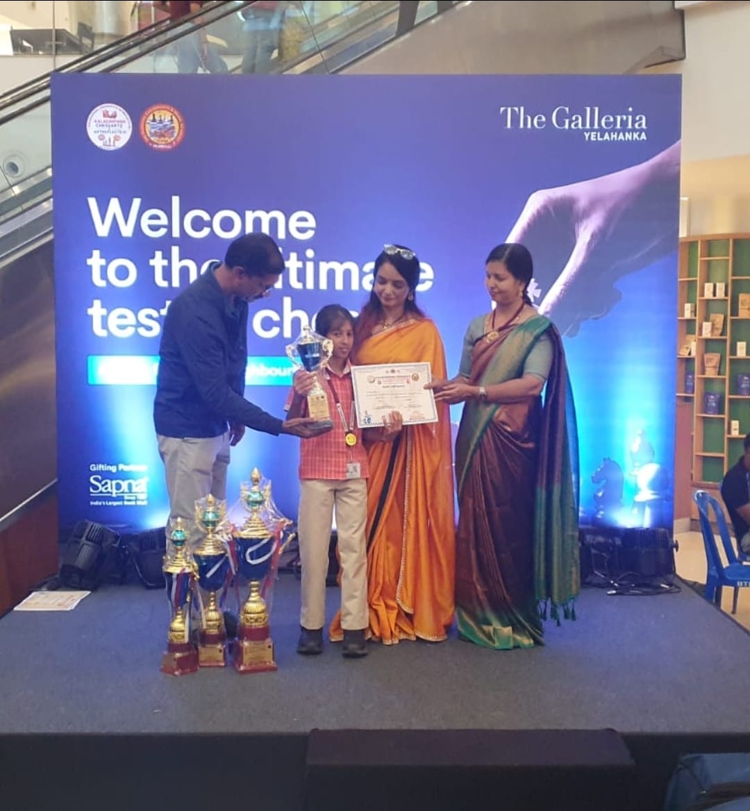 Student receiving trophy and certificate at The Galleria Yelahanka chess tournament, Bangalore